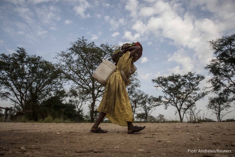 Kobieta niesie wodę w obozie dla uchodźców.