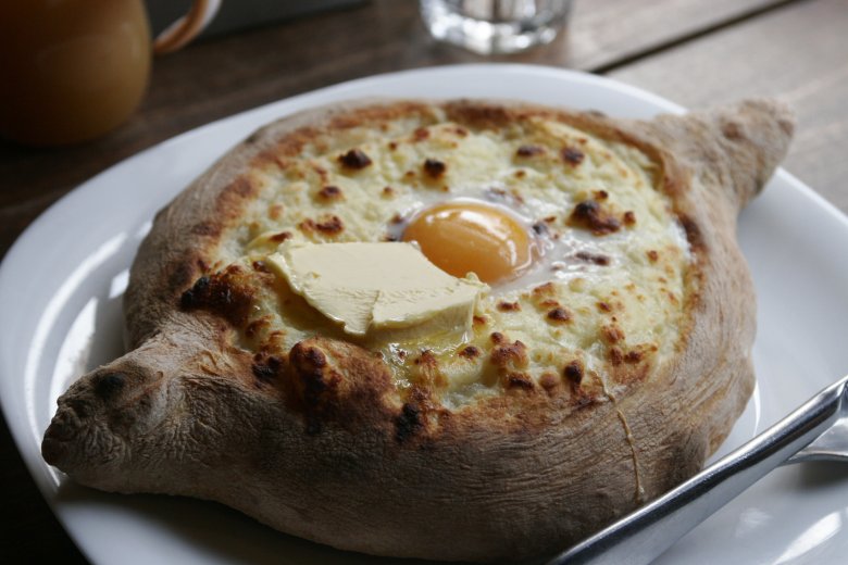 Adżarskie chaczapuri przypomina w smaku nieco pizzę. Przysmak je się palcami, odłamując spieczony brzeg i nabierając ciastem rozbełtane jajko sadzone z serem.