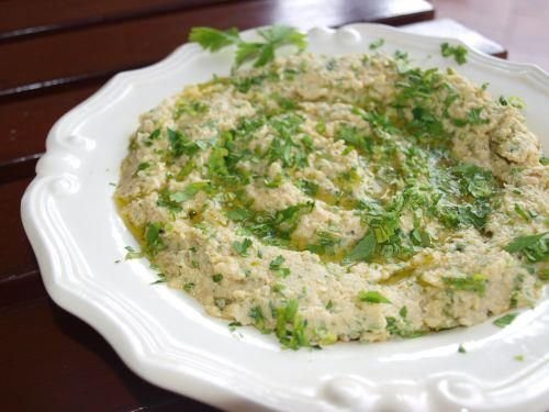 hummus, obficie posypany świeżą natką pietruszki.