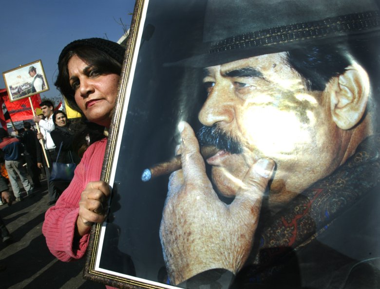 Zwolenniczka Saddama trzymająca jego portret demonstruje w centrum Bagdadu