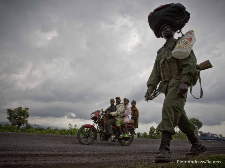 Rodzina w podróży i kongijski żołnierz, na drodze we wschodnim Kongo.