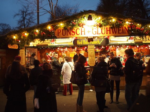 Tradycyjne stragany z grzanym winem i aromatycznymi słodkościami na jarmarku świątecznym.