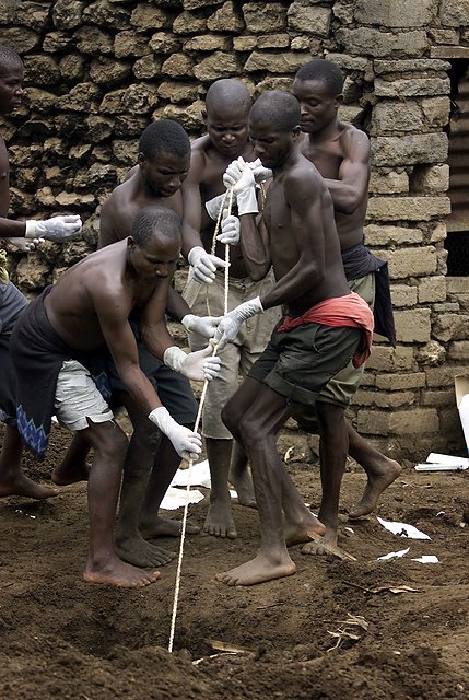 Więźniowie pracujący przy ekshumacji ciał zamordowanych członków sekty.