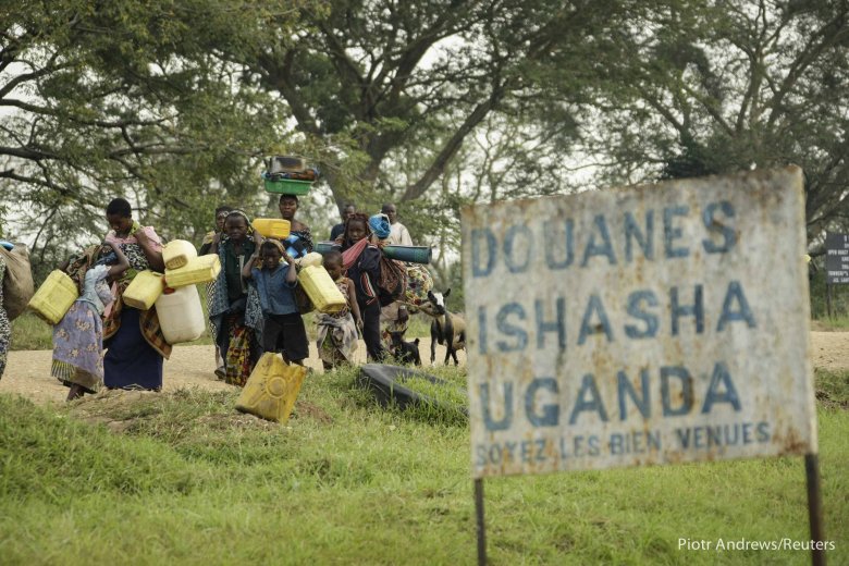 Uchodźcy przekraczający granicę Ugandy.