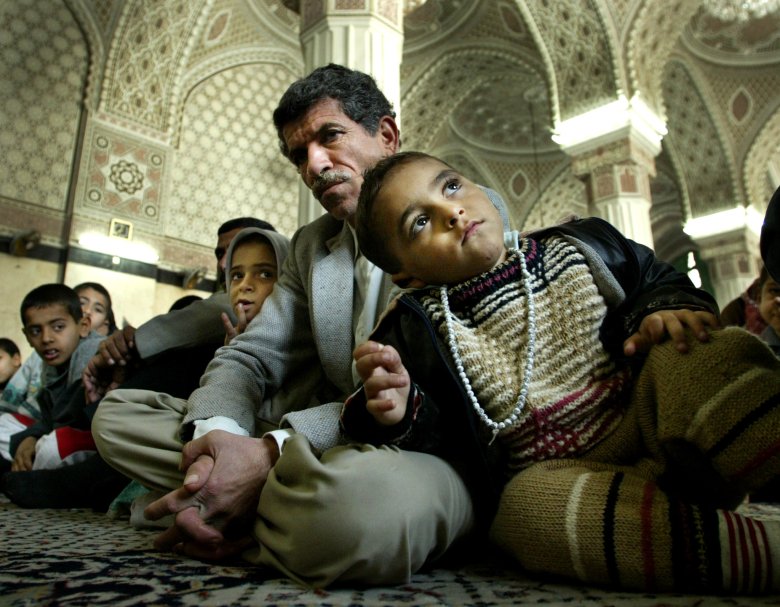 Sunnici czekajacy na rozpoczęcie piątkowych modlitw w meczecie w Sadr City w Bagdadzie