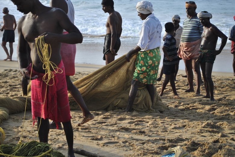 Dzieci kręcą się w pobliżu rybaków z Kerali zarówno przed wypłynięciem w morze, jak i po powrocie. Czasem tylko przeszkadzają przy składaniu sieci. Morze Arabskie, Kovalam, Indie.