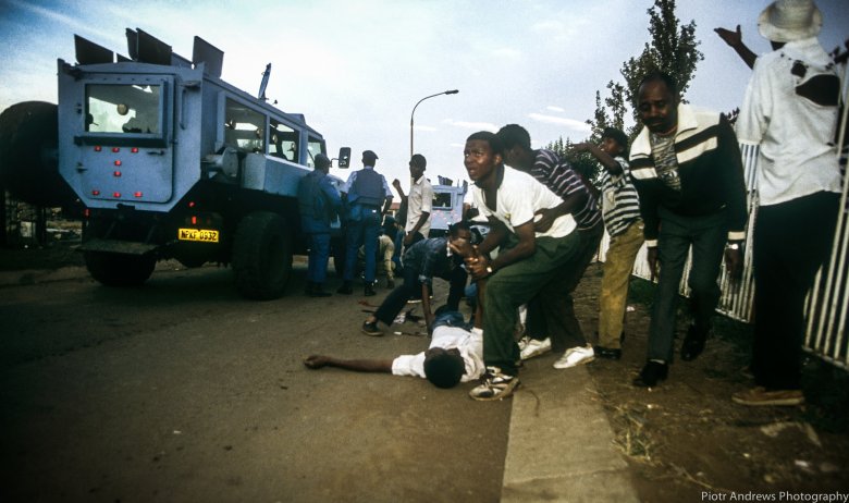 Członkowie ANC próbują odciągnąć kolegę zabitego chwilę wcześniej w trakcie  strzelaniny w Takozie.