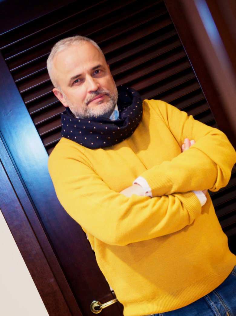 Bogdan ma na sobie:  wełniany szalik z domieszką jedwabiu marki Brooks Brothers. Cena: 468 zł. Sweter marki Brooks Brothers wykonany z wełny Merino. Cena 562 zł. Bawełnianą koszulę button-down marki Brooks Brothers linii RedFleece. Cena: 483zł.