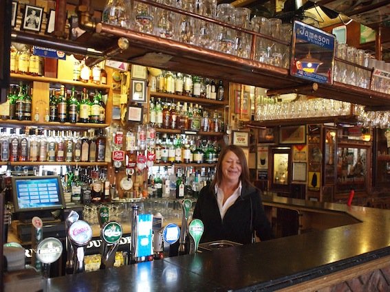 Barmanka za dobrze wyposażonym barem w "The Duke of York".