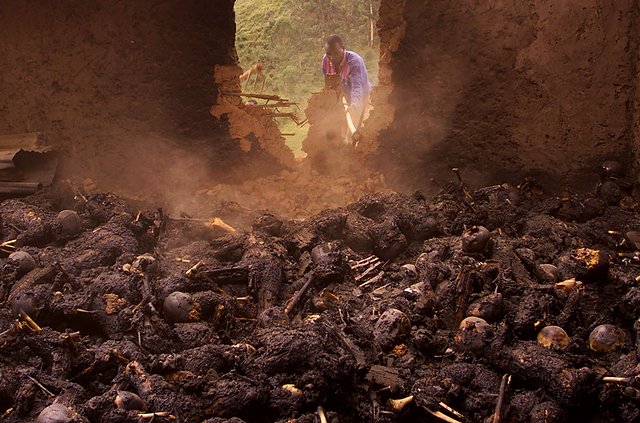 Ugandyjski więzień pracuje przy rozbiórce ściany kościoła w którym spalono żywcem kilkaset osób.