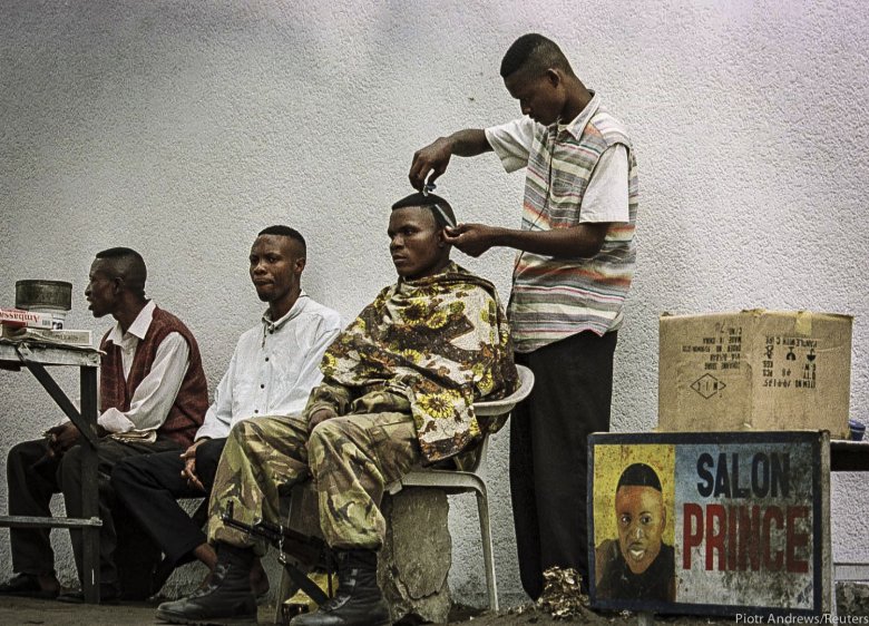 Miejscowy fryzjer strzyże żołnierza lojalnego Kabili