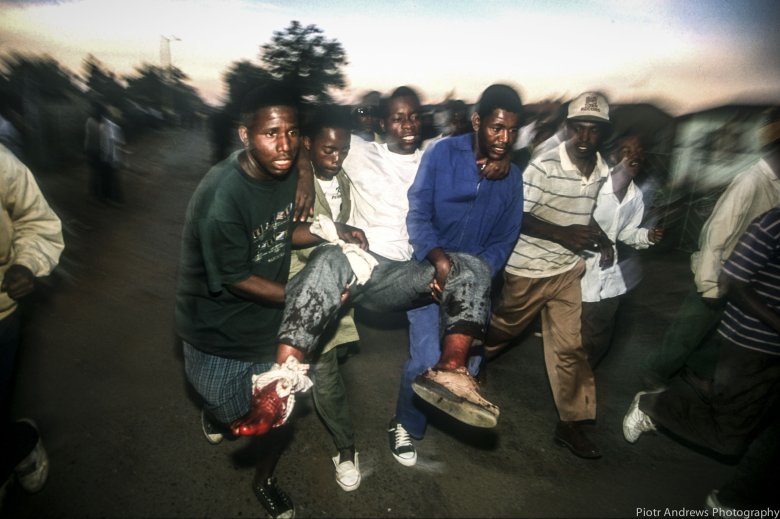 Członkowie ANC niosą rannego po strzelaninie w Takozie.