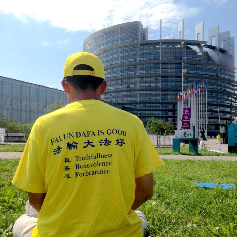 Uczeń Falun Gong (zaawansowana praktyka samodoskonalenia należącą do Szkoły Buddy) medytuje przed budynkiem Parlamentu Europejskiego, Strasburg, 2016