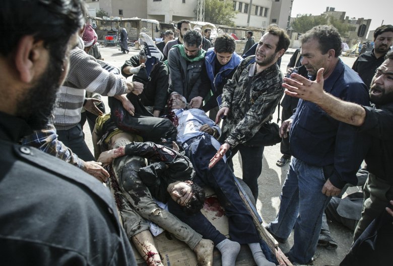 Irakijczycy zbierają ciała ofiar zamachu bombowego w czasie święta Ashura w Karbali.